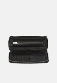 Czarny skórzany portfel z zamkiem błyskawicznym, wyposażony w wiele przegródek na karty, zamykaną na zamek kieszeń oraz gładkie wnętrze.