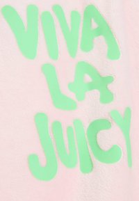 Rozā audums ar izteiksmīgu zaļu uzrakstu "VIVA LA JUICY". Tekstūra izskatās mīksta un pūkaina ar gludu apdari.