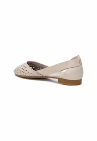 Scarpa piatta rosa chiaro con design perforato, tomaia in morbida pelle, interno imbottito e suola in gomma bassa. Cinta elastica incrociata sul tallone.