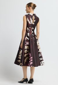 Blumenmusterkleid aus dunklem Burgunderstoff mit tailliertem Oberteil, ärmellosem Design und ausgestellt Rock; verfügt über einen Kragen und einen Schlüssel-Ausschnitt hinten.