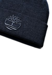 Berretto lavorato a maglia di colore navy con finitura testurizzata, risvolto pieghevole e logo di un albero ricamato sulla parte frontale. Tessuto morbido che offre calore.