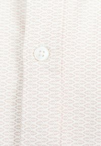 Camisa blanca con un sutil patrón de hojas rosas, presenta una tapeta cosida y un botón blanco de cuatro agujeros. Material de algodón suave.