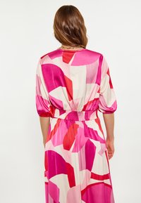 Lungo vestito di seta con un motivo astratto rosa e rosso, vita elasticizzata e maniche a palloncino con una texture liscia e lucida.