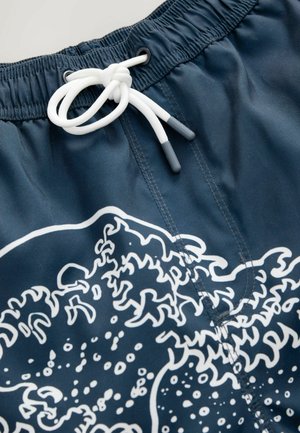 Marineblaue Badeshorts aus glattem Material mit einem Bund, der einen weißen Kordelzug hat. Auffälliges Design mit weißen Wellenmotiven und Nähten.