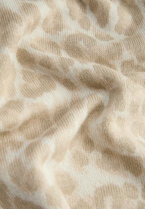 Beige en witte gebreide stof met een zacht, golvend patroon en zichtbare textuure vouwen.