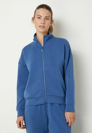 Giacca in pile con zip di colore blu intenso, caratterizzata da un colletto alto, maniche lunghe e polsini elasticizzati. Tessuto liscio con una vestibilità comoda.