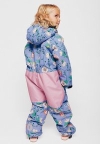 Mono de nieve impermeable y colorido con estampado floral en tonos azules y rosas. Cuenta con capucha, cintura fruncida y diseño aislante para mayor calidez.