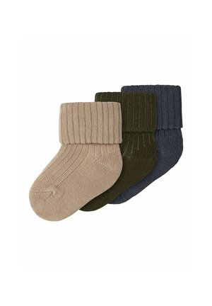 Trois paires de chaussettes pour bébé en tricot côtelé avec revers pliés en beige, vert foncé et bleu marine, disposées en chevauchement sur un fond blanc.