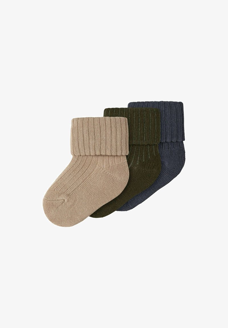 Trois paires de chaussettes pour bébé en tricot côtelé avec revers pliés en beige, vert foncé et bleu marine, disposées en chevauchement sur un fond blanc.