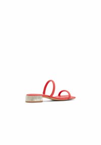 Röda platta sandaler med två rundade remmar, en texturerad beige detalj på hälen och en slät, platt sula.