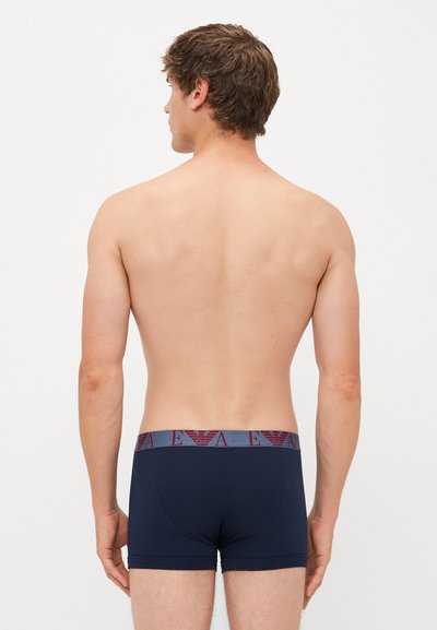 Dunkelblaue Herren-Boxershorts mit einem kontrastierenden grauen Bund, der ein rotes Logo trägt. Das Material wirkt glatt und elastisch, entworfen für Komfort.