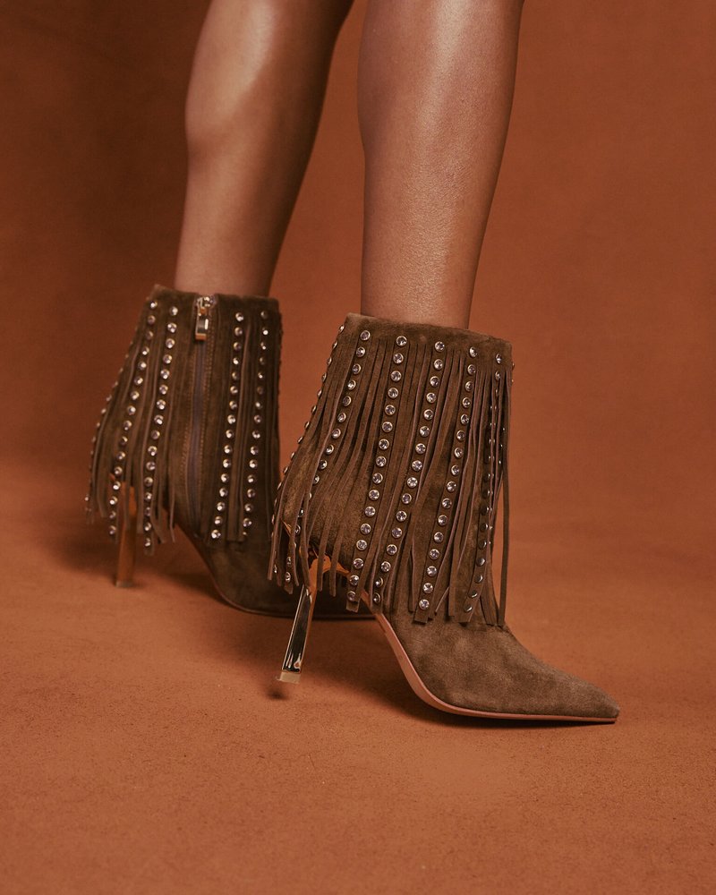 Olivengrüne Wildleder-Stiefeletten mit Fransenverzierungen und Metallnieten. Die spitze Zehenpartie und der transparente Absatz verleihen ein einzigartiges Design.