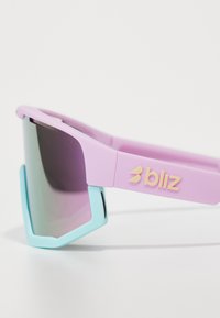 Zonnebril met een matte lavendel montuur, blauwe accenten en donker getinte lenzen. Heeft een "bliz" logo in pastelgeel op de poot.