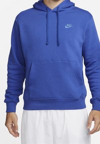 Felpa blu realizzata in tessuto morbido con tasca a marsupio e cappuccio con cordino regolabile. Presenta un piccolo logo Nike in contrasto sul petto.