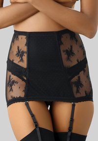 Schwarzer Strumpfhosenrock mit transparenten Punkten und floralen Spitzenpaneelen, verstellbaren Trägern und einem strukturierten Bund mit gewellten Kanten.