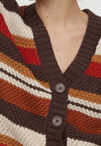 Knit cardigan featuring a v-neck, multicolored stripes in brown, orange, and cream, with two dark buttons and a textured finish.
