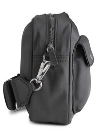 Fekete szövet táska textúrázott felülettel, felső cipzárral, oldalsó zsebbel, fémből készült szerelvényekkel és állítható pánttal.