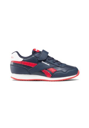 Zapatilla azul marino con acentos rojos, que presenta una parte superior sintética lisa, cierre de cordones y tiras de Velcro, y una suela de goma blanca.