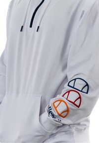 Sudadera blanca con capucha, que presenta un cuello con media cremallera, un bolsillo frontal y acentos de logotipo en rojo, azul marino y naranja en la manga izquierda.