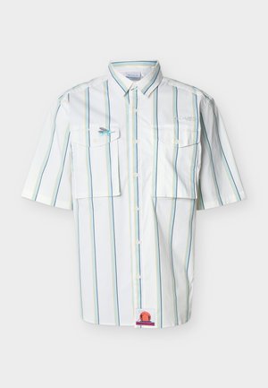 Biela krátka košeľa s gombíkmi na zapínanie, svislé modré, žlté a zelené pruhy, dve náprsné vrecká a malým vyšívaným logom na ľavom vrecku.