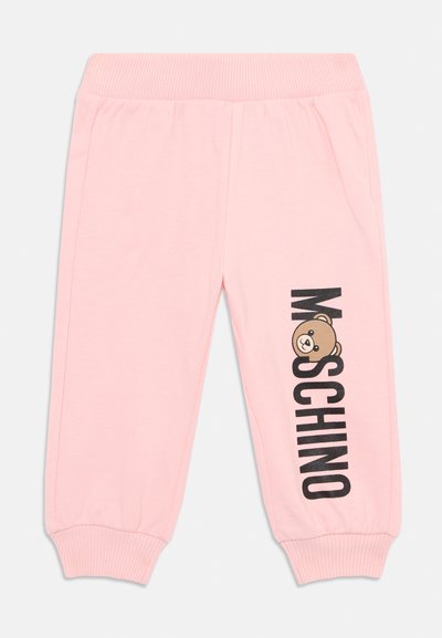Joggers en coton rose avec une taille côtelée. Présente un logo "Moschino" noir et un graphique d'ours brun sur la jambe gauche. Poignets élastiques aux chevilles.