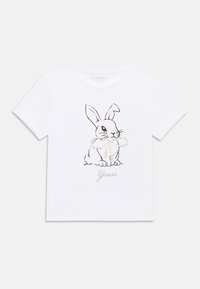 Λευκό βαμβακερό μπλουζάκι με μαύρο περίγραμμα κουνελιού και διακοσμητικά μαργαριτάρια. Η λέξη "Guess" είναι τυπωμένη σε ασημί κάτω από το γραφικό. Κοντά μανίκια.