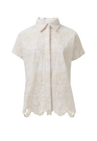 Camisa de manga corta con cuello en color crema claro, que presenta un intrincado bordado y detalles de dobladillo en forma de ondas. Tela texturizada con un diseño estampado.