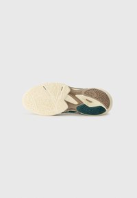 Shoe sole with intricate textured patterns. Color gradient from cream to tan and teal accents. Made of rubber for durability and traction.