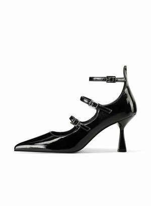 Décolleté in vernice nera con punta affusolata, tre cinturini regolabili e un design del tacco geometrico unico. Superficie liscia e lucida.