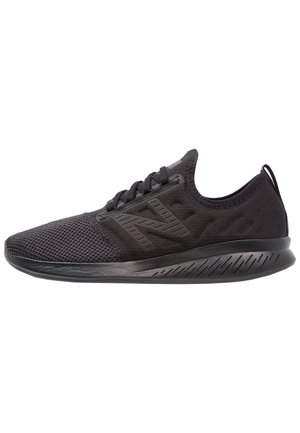 Baskets de sport noires avec dessus en mesh, fermeture à lacets, semelle coussinée et logo de marque sur le côté.