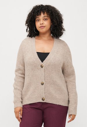 Beige knitted cardigan with a V-neck, ribbed cuffs, and three buttons down the front, paired with dark maroon pants. Soft texture.