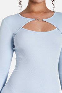 Maglietta a maniche lunghe a coste blu chiaro con un design a taglio sul collo e un fermaglio argentato con scritte.