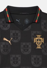 Čierny športový dres so zlatým logom Puma, zlatým erbom Portugalskej futbalovej federácie a golierom s červeno-zeleno-zlatými pruhmi.