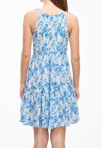 Blaues Blumendruckkleid mit Spaghetti-Trägern, gerafftem Oberteil und gestuftem Rock. Hergestellt aus leichtem Stoff mit weicher Textur.