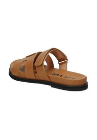 Sandal de color tostado con tres correas anchas, hebilla ajustable, parte trasera abierta y suela negra plana. Material sintético texturizado con un acabado suave.
