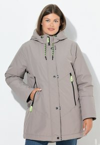 Giacca imbottita grigia chiara con cappuccio, tasche con zip nere e lacci verdi. Presenta un design a trapunta e chiusura con bottoni a pressione.