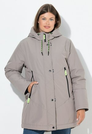 Veste matelassée gris clair avec capuche, poches zippées noires et cordons de serrage verts. Présente un design matelassé et une fermeture à boutons-pression.