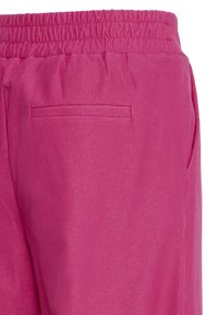 Pantalon rose vif avec une taille élastique et une poche passepoilée unique au dos du côté droit.