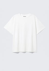 T-shirt en coton blanc avec une coupe décontractée, des manches courtes et un col rond. Présente un design minimaliste, sans motifs ni accents.