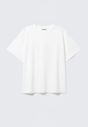 Tricou alb din bumbac, cu o croială lejeră, mâneci scurte și guler clasic. Are un design minimalist, fără modele sau accente.