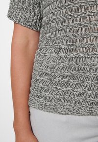 Lichtgewicht, kortemouwen trui in grijs en zwart breiwerk met een gestructureerde weving. Heeft een ontspannen pasvorm en ribbels aan de mouwen en de zoom.