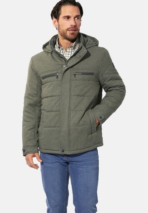 Green padded jacket with a hood, featuring two zippered chest pockets, button cuffs, and a textured fabric, worn over a checkered shirt.