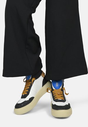 Sneaker alte in pelle bianca con dettagli in glitter neri, suola in gomma beige, lacci marroni e interno blu.