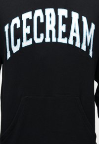Μαύρο hoodie από βαμβάκι με τσέπη καγκουρό. Διαθέτει την επιγραφή "ICECREAM" σε μεγάλες, έντονες, ανοιχτό μπλε γράμματα στο στήθος.