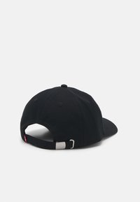 Casquette de baseball noire en tissu, avec une visière courbée, une sangle ajustable avec fermeture métallique et des coutures sur le haut.