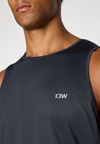 Schwarzes ärmelloses Sporttanktop aus strukturiertem Stoff mit einem weißen "ICIW"-Logo auf der linken Brust.
