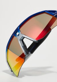 Lunettes de sport avec une monture métallique bleue, des verres miroités dégradés en orange et rouge, et des accents en caoutchouc noir pour une prise en main optimale.