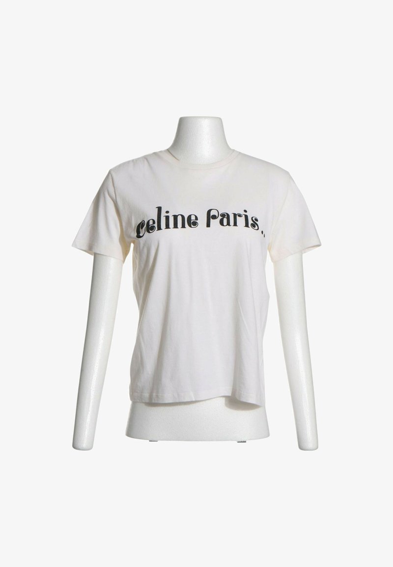 T-shirt blanc à manches courtes sur mannequin avec texte noir "celine Paris" sur la poitrine, fond uni.
