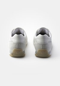 Baskets blanches en cuir et en suede avec une finition texturée, dotées d'une semelle intérieure rembourrée, d'une semelle extérieure en caoutchouc et d'un logo discret au niveau du talon.