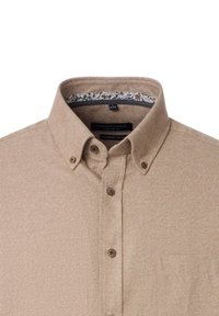 Lysebrunt button-up skjorte med et struktureret stof. Har en klassisk krave, brune knapper og et mønstret inderside. Komfortabel pasform.